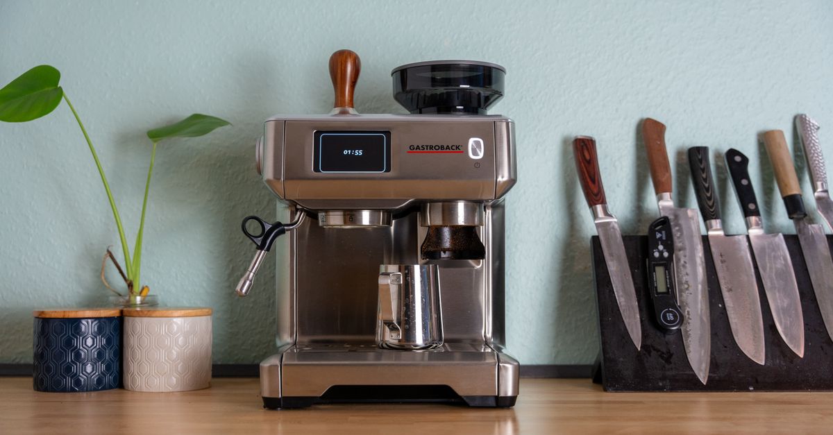 A sleek espresso machine with knives and plants on a wooden kitchen counter, showcasing a homey kitchen vibe.